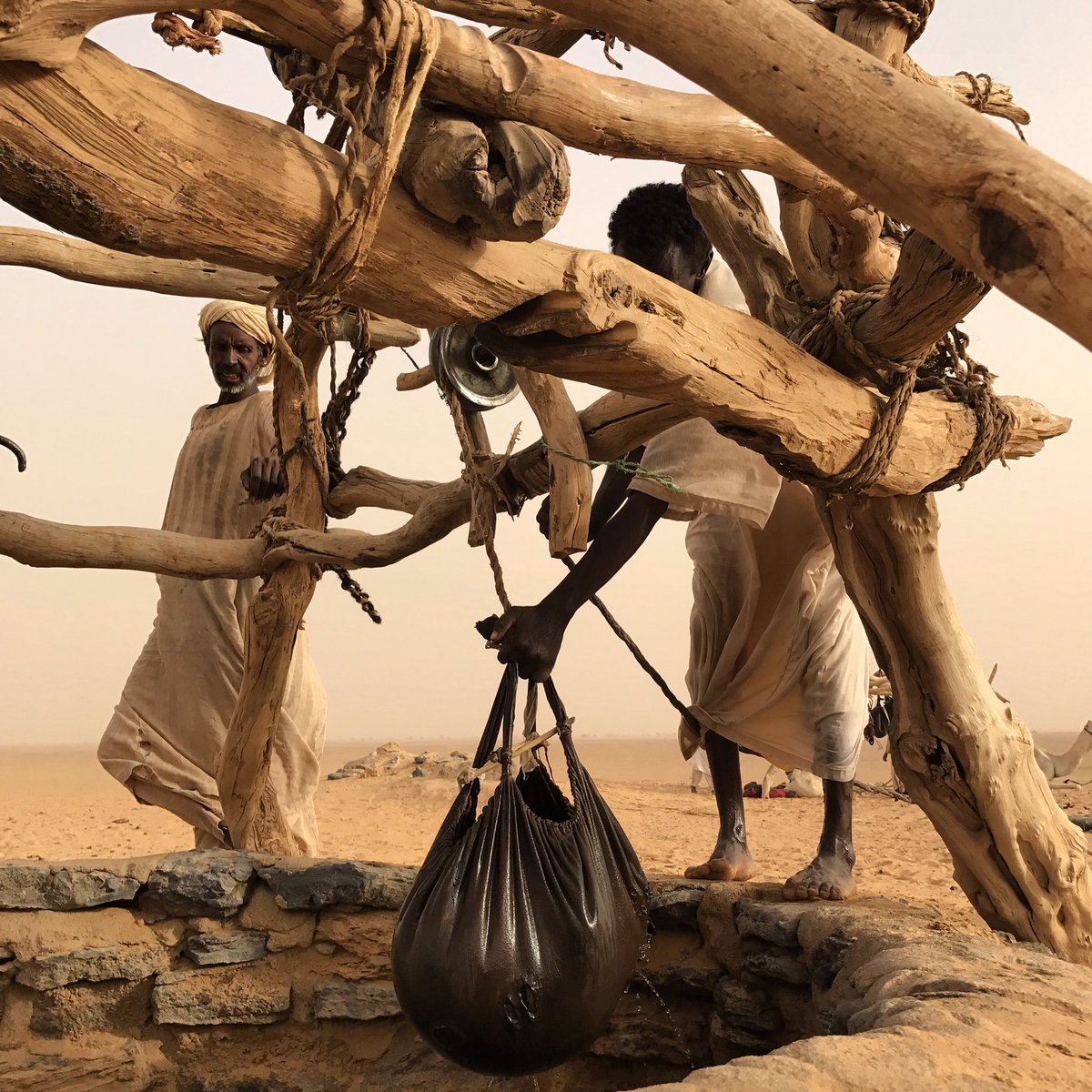 上图：撒哈拉沙漠的贝都因人用山羊皮水袋从Bayuda Desert的井里打水，皮袋包着水，就像云「将水包在密云中，云却不破裂」（伯二十六8）。